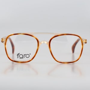 May include: Tortoise shell eyeglasses with gold accents and a clear lens. The brand name "ffaro" is printed on the right lens.