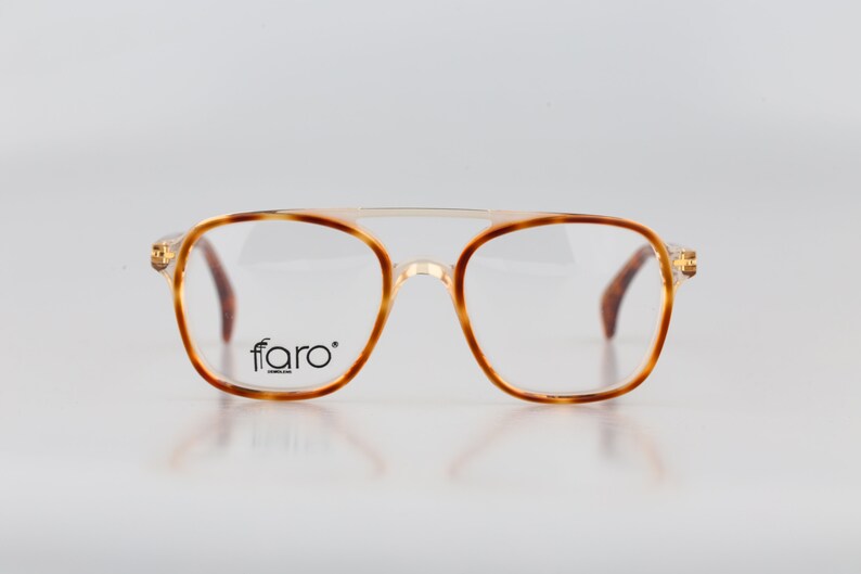 May include: Tortoise shell eyeglasses with gold accents and a clear lens. The brand name "ffaro" is printed on the right lens.