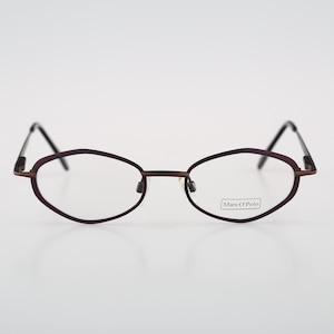 May include: A pair of oval-shaped eyeglasses with a purple frame and clear lenses. The brand name "Marc O'Polo" is printed on the right lens.