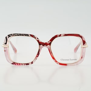 May include: A set of three ceramic mugs with a speckled, cream-colored glaze. Each mug features a different hand-painted design: a blue and green leaf, a yellow flower, and a red berry. The mugs have a simple, modern design.