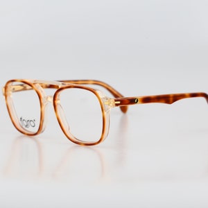 May include: Tortoiseshell eyeglasses with clear lenses and a gold accent on the bridge.