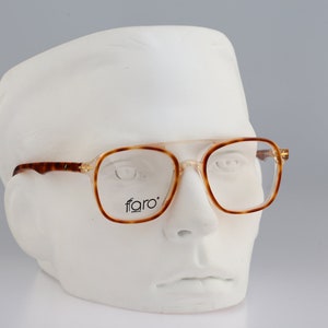 May include: Tortoise shell eyeglasses with clear lenses and a 'faro' logo on the frame.