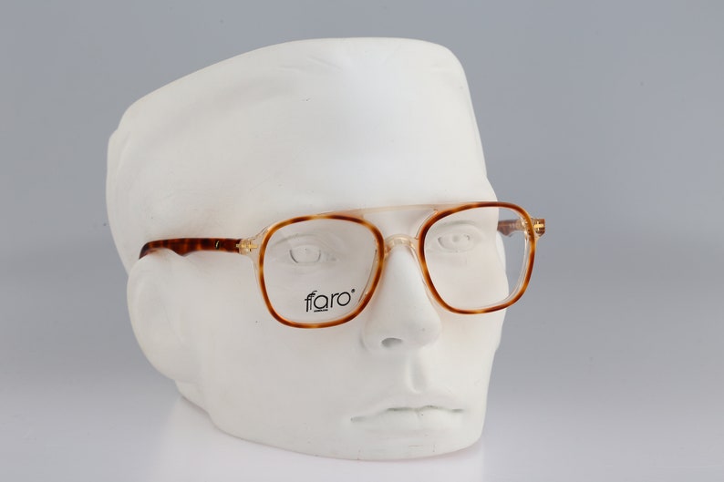 May include: Tortoise shell eyeglasses with clear lenses and a 'faro' logo on the frame.