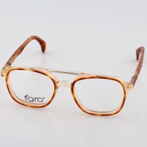May include: Tortoise shell eyeglasses with a clear frame and the word "faro" printed on the right lens.