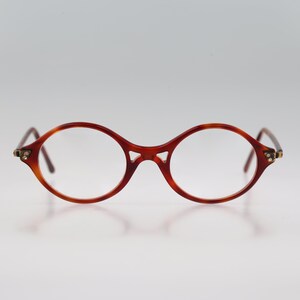 May include: A pair of round, tortoiseshell eyeglasses with gold accents on the temples.