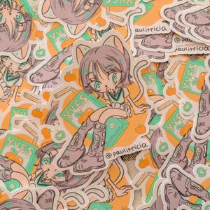 Puede incluir: Una colección de pegatinas con un personaje de chica-gato de dibujos animados con ojos verdes, que lleva un uniforme escolar y botas. Las pegatinas tienen un fondo naranja con ilustraciones de manzanas y lápices, y el texto "YVES" y "@paulitricia".