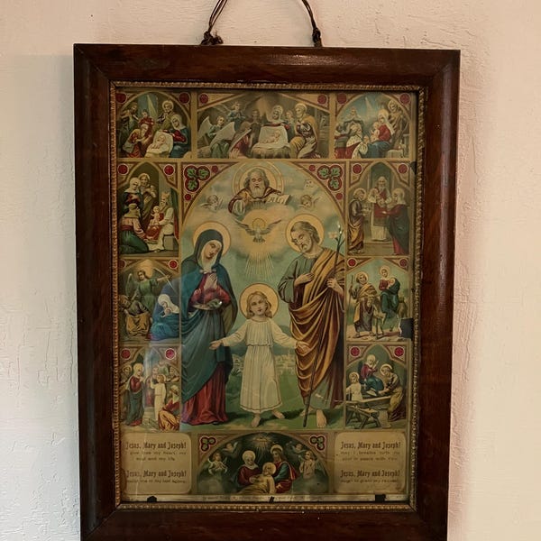 Antique Framed Religious Catholic Lithograph features a central picture of the Holy family surrounded by smaller icons, red oak frame