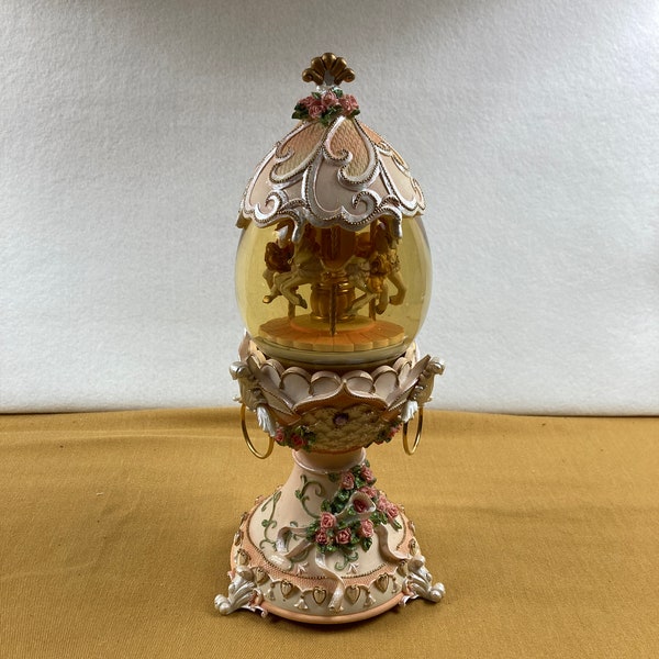 Vintage ornate sculpted resin and glass musical carousel glitter snow globe that turns and plays The Entertainer when wound.