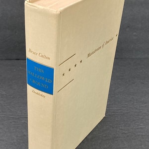 May include: A vintage hardcover book titled "This Hallowed Ground" by Bruce Catton. The book is part of the Mainstream of America series and is published by Doubleday.