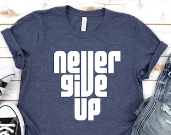 May include: A navy blue t-shirt with the words "never give up" printed in white on the front. The shirt is made of a soft, comfortable material and is perfect for everyday wear.