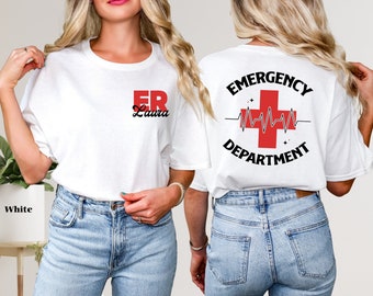 Peut inclure: T-shirt blanc avec le texte "ER Laura" sur le devant et "EMERGENCY DEPARTMENT" avec une croix rouge et un graphique de battement de cœur au dos.
