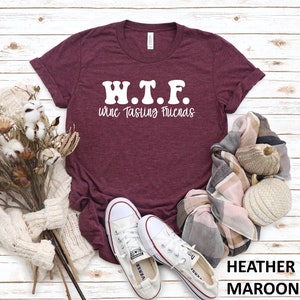 K&ouml;nnte beinhalten: Heather-marronfarbenes T-Shirt mit wei&szlig;em Text, der "W.T.F. Wine Tasting Friends" lautet.