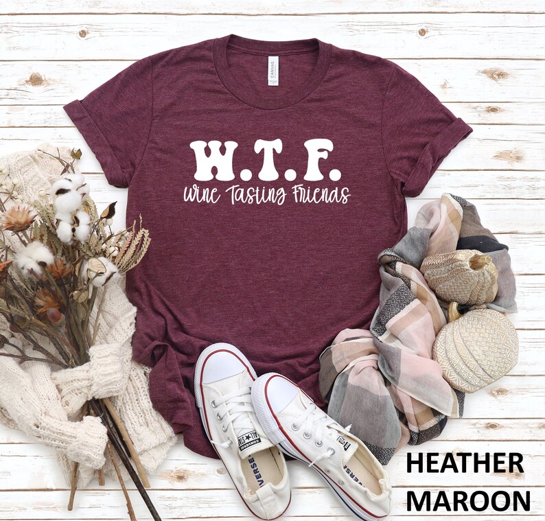 K&ouml;nnte beinhalten: Heather-marronfarbenes T-Shirt mit wei&szlig;em Text, der "W.T.F. Wine Tasting Friends" lautet.