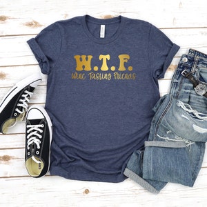 K&ouml;nnte beinhalten: Ein marineblaues T-Shirt mit goldener Aufschrift "W.T.F. Wine Tasting Friends".