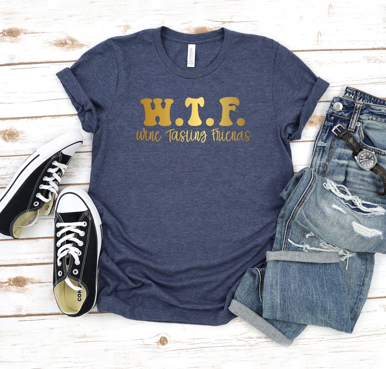 K&ouml;nnte beinhalten: Ein marineblaues T-Shirt mit goldener Aufschrift "W.T.F. Wine Tasting Friends".