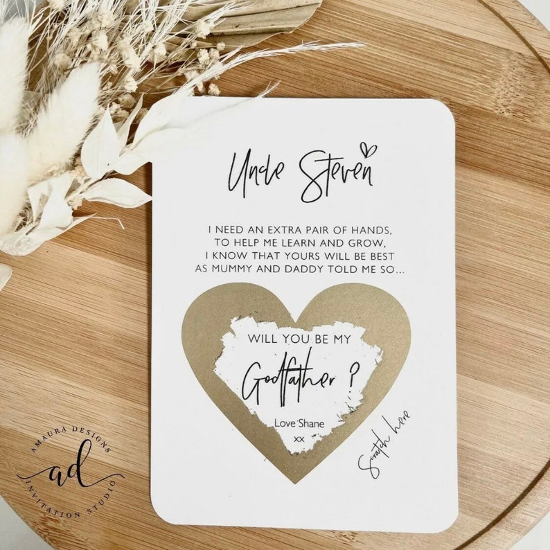 May include: A white card with gold heart-shaped paper on top. The card says "Uncle Steven" and "Will you be my Godfather?" with the text "Love Shane XX" below. The card also has the text "Swatch here" written on the bottom right corner.