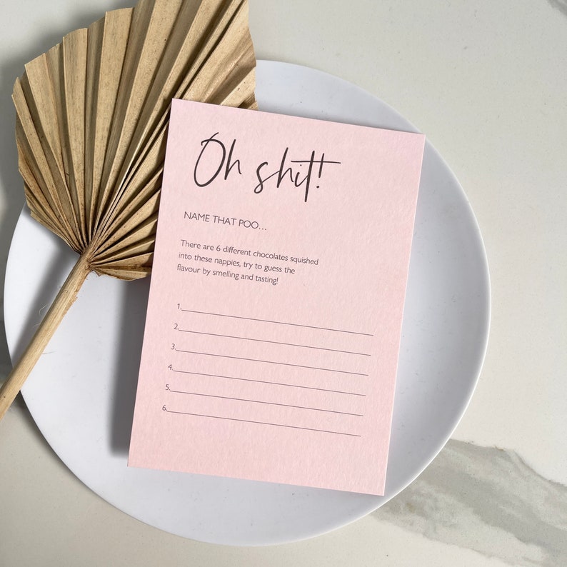 May include: A pink card with the text "Oh shit!" and "NAME THAT POO..."  There are 6 blank lines below the text, with numbers 1 through 6 next to each line.