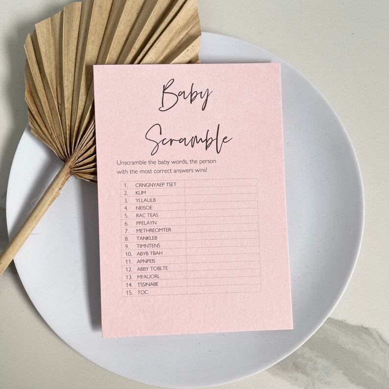 May include: A pink printable baby shower game card with the title "Baby Scramble". The game instructions are to unscramble the baby words and the person with the most correct answers wins. The game includes 15 words to unscramble.