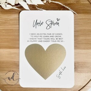 May include: A white card with a gold heart shape for a handprint. The card has the text "Uncle Steven" and a message about needing an extra pair of hands to help learn and grow. The text "Snatch here" is written below the heart.