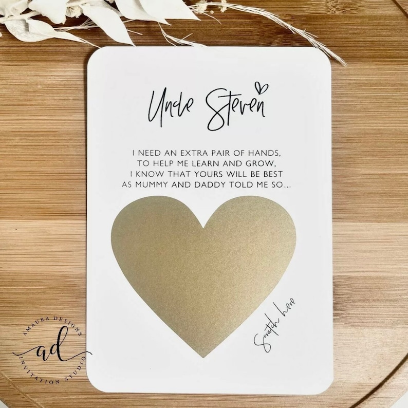 May include: A white card with a gold heart shape for a handprint. The card has the text "Uncle Steven" and a message about needing an extra pair of hands to help learn and grow. The text "Snatch here" is written below the heart.
