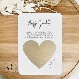 May include: White card with a gold heart shape and the text "Aunty Jordana" and "I need an extra pair of hands, to help me learn and grow. I know that yours will be best as mummy and daddy told me so..." with the words "Swatch here" written below the heart.