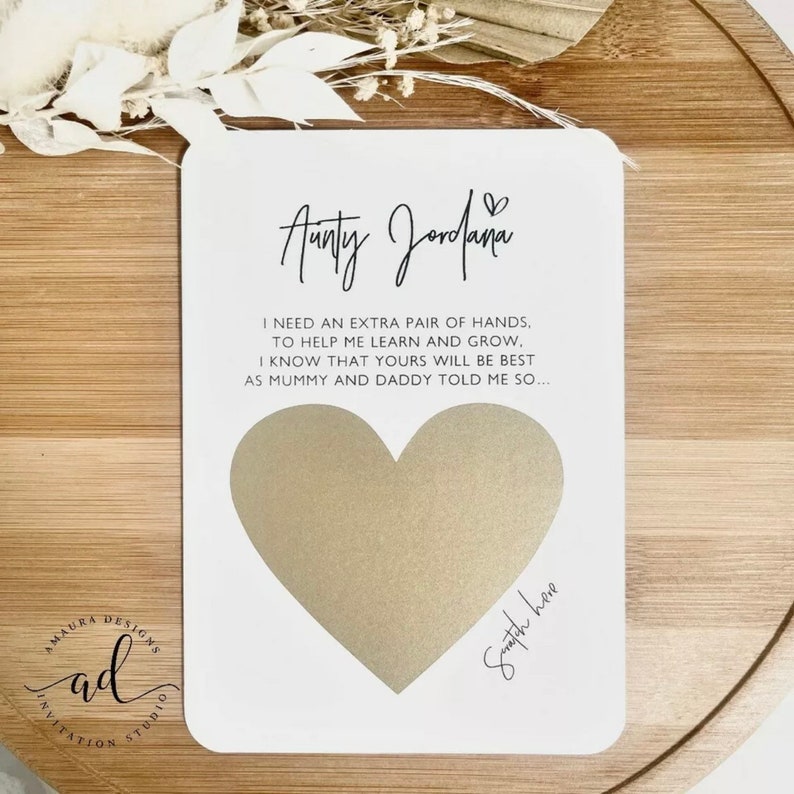 May include: White card with a gold heart shape and the text "Aunty Jordana" and "I need an extra pair of hands, to help me learn and grow. I know that yours will be best as mummy and daddy told me so..." with the words "Swatch here" written below the heart.