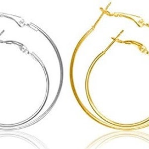 May include: A pair of hoop earrings, one gold and one silver. The earrings are simple and classic, with a smooth finish.