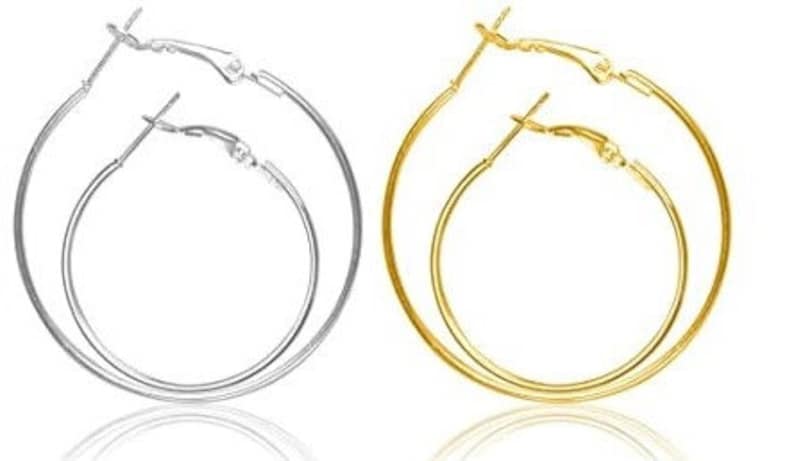 May include: A pair of hoop earrings, one gold and one silver. The earrings are simple and classic, with a smooth finish.
