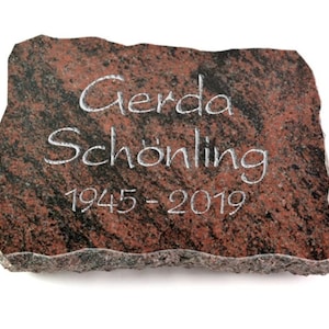 Könnte beinhalten: Ein roter Granitstein mit einer weißen Inschrift, die "Gerda Schönling 1945-2019" lautet.