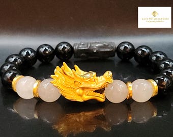 May include: A black onyx and rose quartz bracelet with a gold dragon charm. The bracelet features a black onyx bead, a rose quartz bead, and a gold dragon charm. The bracelet is made of high-quality materials and is perfect for everyday wear.