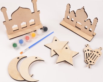 May include: A wooden craft kit for decorating with paint. The kit includes two mosque shapes, two crescent moons, two stars, and two lanterns. The kit also includes a paintbrush and six small bottles of paint in green, blue, red, yellow, orange, and black.
