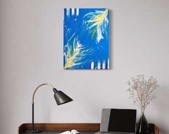 May include: Abstract painting on canvas featuring two stylized feathers in yellow and white against a bright blue background. Vertical white stripes frame the artwork. The painting is displayed on a wall above a desk with a lamp, laptop, and vase.