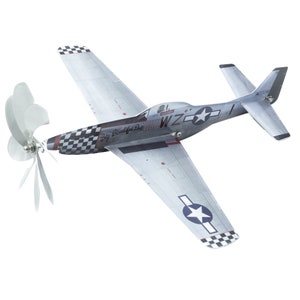 May include: A gray and white model airplane with a propeller. The plane has a checkered pattern on the wings and tail, and the words "Big Beautiful Doll" are written on the side. The plane also has a star on the tail and the letters "WZ" on the side.