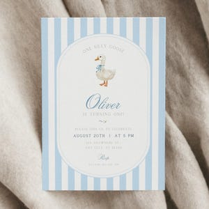 Op de afbeelding: Een blauw-wit gestreepte uitnodigingskaart met een illustratie van een witte gans. De tekst luidt "One Silly Goose Oliver is turning one! Please join us to celebrate! August 20th at 5 PM 123 Anywhere St Any City, ST 12340  RSVP".