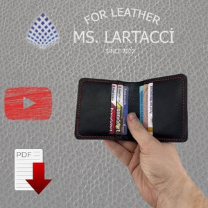 May include: A black leather wallet with red stitching, open to reveal multiple cards, including a Bankamatik card, a Ziraat Bankası card, and a Hanıvart card. The wallet is held in a hand.