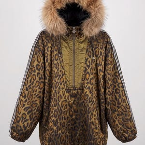 Puede incluir: Una chaqueta de manga larga con estampado de leopardo en marrón y negro, cierre frontal de media cremallera y capucha ribeteada con piel sintética marrón gruesa y esponjosa. Las mangas tienen rayas blancas y el dobladillo incluye un cordón.