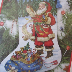 May include: A Christmas stocking with a Santa Claus design. Santa is holding a list and a bird. The stocking is filled with toys and a small Christmas tree.