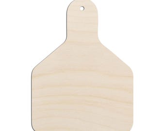 May include: A light-colored, unfinished wooden tag with a smooth, flat surface and a rounded top section featuring a small, centered circular hole for hanging. The shape resembles a livestock ear tag with a wide base and a narrow neck.