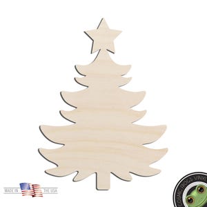 May include: A light-colored, unfinished wooden cutout in the shape of a Christmas tree with a star at the top. The tree has four tiers of branches with curved edges. In the bottom left corner, there is a small American flag icon with the text MADE IN THE USA. A circular logo with a green frog and the text COSMIC FROGS VINYL is in the bottom right corner.