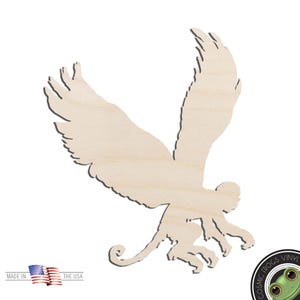 May include: A light-colored, flat wooden cutout in the shape of a winged monkey with its wings spread wide in flight. The silhouette features a monkey body with large, feathered wings, a curled tail, and limbs extended, showing a natural wood grain.