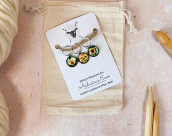 May include: Set of three sunflower stitch markers with a silver ring and a brown twine. The markers are packaged in a small white drawstring bag with a card that reads "Stitch Markers by Audacious Ewe Leave the Flock Behind audaciousewe.etsy.com"