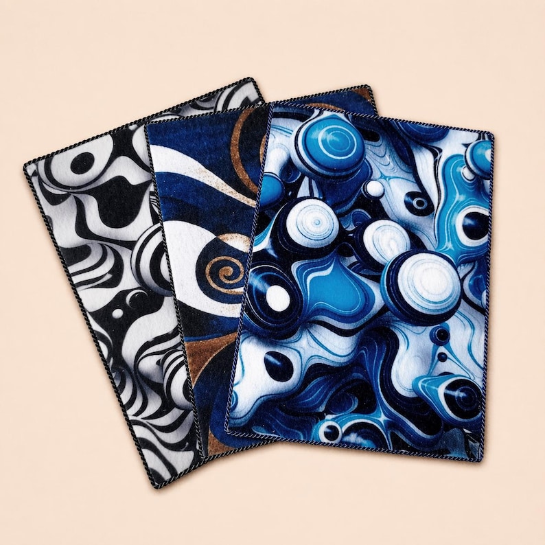 Peut inclure: Trois dessous de verre d'art abstrait avec des motifs noirs, blancs et bleus. Les dessous de verre pr&eacute;sentent des motifs tourbillonnants et des formes g&eacute;om&eacute;triques. Chaque dessous de verre a une bordure noire.