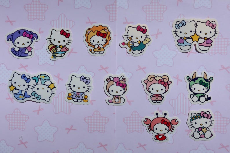 May include: A set of 12 Hello Kitty stickers featuring Hello Kitty dressed as different zodiac signs. The stickers are on a pink background with white stars and pink bows.