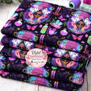 Puede incluir: Una pila de tela estampada con un diseño místico y colorido. El patrón incluye fantasmas, manos, mariposas, botellas de pociones, cristales y el texto "I'M NOT ANTISOCIAL I TALK TO GHOSTS". La tela es predominantemente negra con acentos vibrantes.
