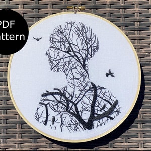 Könnte beinhalten: Ein schwarz-weißes Stickmuster einer Personensilhouette mit Ästen und Vögeln. Das Muster befindet sich in einem runden Stickrahmen. Der Text "PDF pattern" befindet sich in einem schwarzen Kreis oben links im Bild.