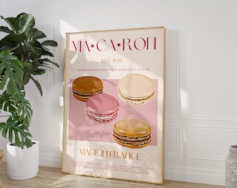 May include: A pink and gold poster with the text "MA-CA-RON" in a pink font. The poster features a graphic of four macarons, two with a brown filling and two with a pink filling. The text "EST. 1959" and "MERINGUE-BASED CONFECTION BAKED FRESH IN STORE" is in a smaller font. The poster also includes the text "MADE IN FRANCE".