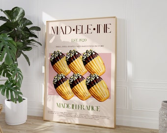 May include: A poster with a pink background featuring the text "MAD ELE-INE EST. 1920 SMALL SHELL-SHAPED CAKES BAKED FRESH IN STORE MADE IN FRANCE". The poster features six shell-shaped madeleine cookies with chocolate and nuts on top.