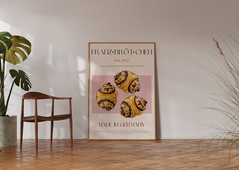 May include: A poster with a pink background featuring the text "FRANZ-BR&Ouml;T-CHEN" and "MADE IN GERMANY". The poster also features three pastry rolls with a brown and white swirl design.