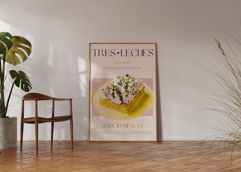 Puede incluir: Un p&oacute;ster con un dise&ntilde;o minimalista que presenta una rebanada de pastel Tres Leches con cobertura de pistacho. El p&oacute;ster est&aacute; enmarcado en un marco de madera clara y tiene el texto "Tres Leches Est. 1989 Sponge Cake Soaked in Sweetened Milk Made in Mexico" en una fuente dorada.