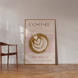 May include: A poster with a minimalist design featuring a cup of coffee with latte art. The poster is framed in a light wood frame and has the text "COFFEE EST. 1979 MADE IN ITALY" on it.
